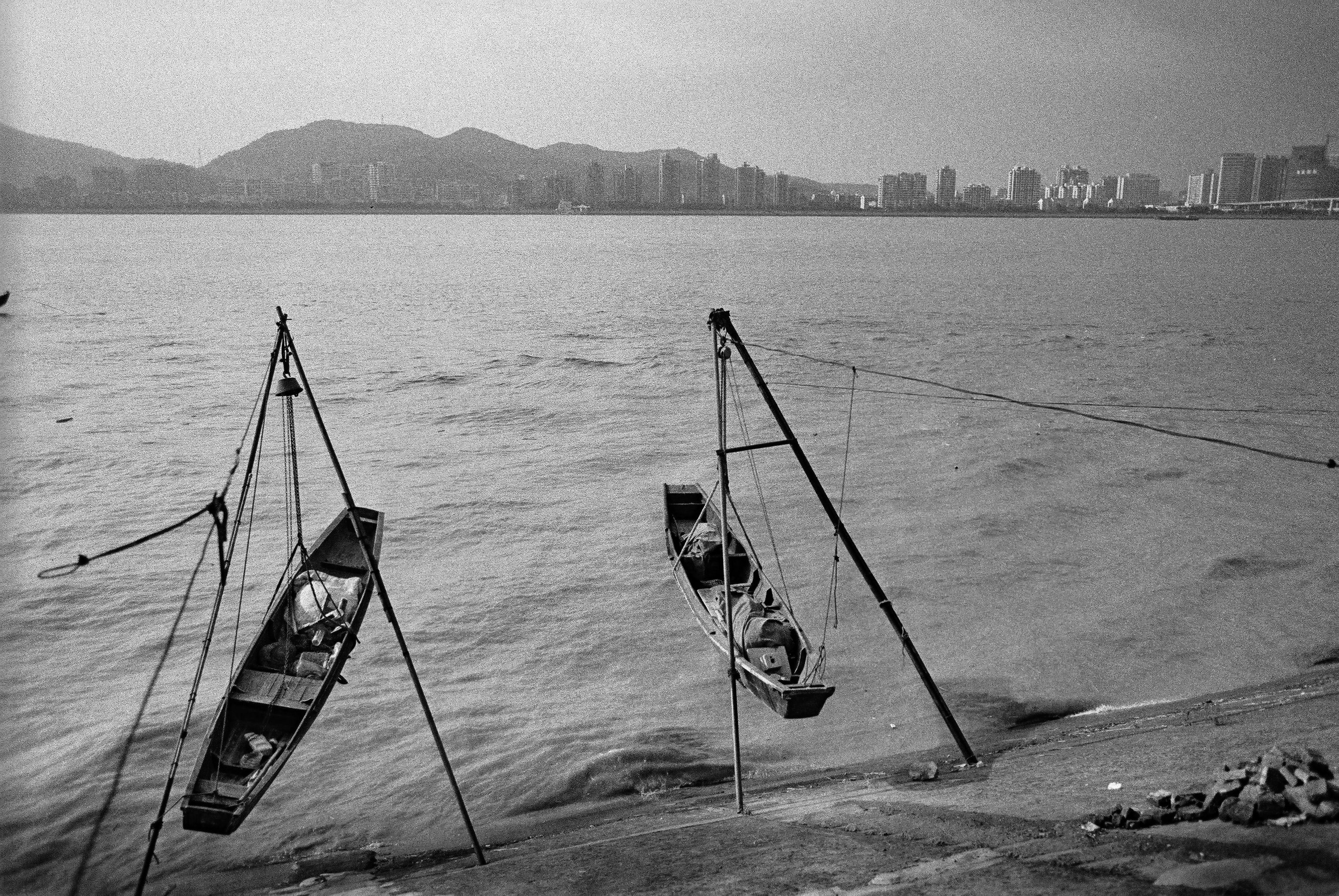 Fishing boats suspended above the Qiantang River with Hangzhou in the distance
